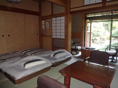 a room with two beds and a table in it at Mokkoan in Tokyo
