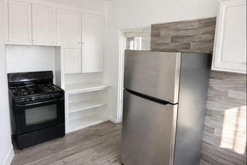a kitchen with a stainless steel refrigerator and an oven at Hoover Homes for the Soul in Los Angeles