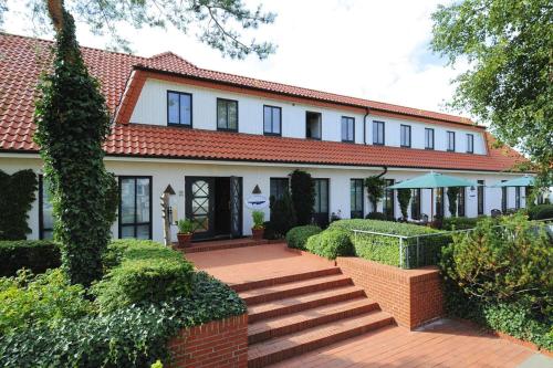 a large white house with a red roof at Appartements Post Hiddensee, Vitte in Vitte