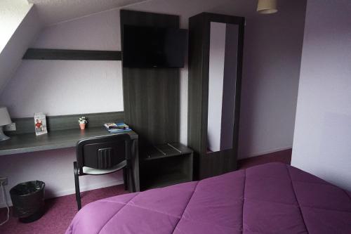 a bedroom with a purple bed and a desk at Lys Hôtel in Halluin