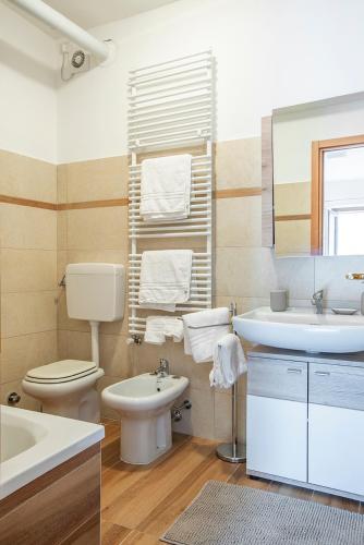 a bathroom with a sink and a toilet and a mirror at Il Nido di Somadino in Casargo