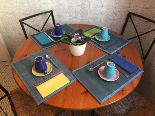 a wooden table with plates and mugs on it at Delightful apartment 100 meters from the Colosseum in Rome