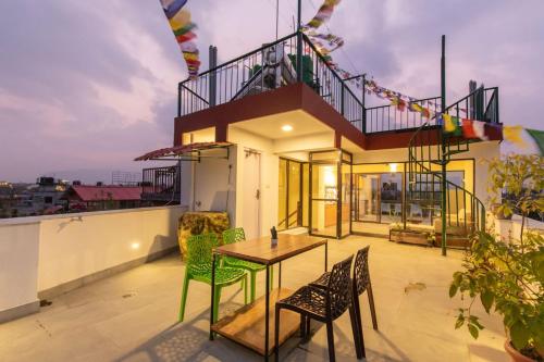 una casa con un tavolo e delle sedie su un balcone di Dwell Casa a Patan