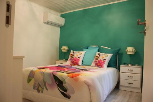 a bedroom with a bed and a green wall at Casa D'Aldeia in Geres