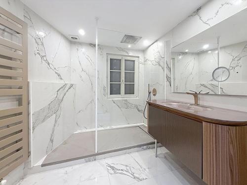 a white bathroom with a shower and a sink at Beautiful longere with pool in Courcelles-lès-Gisors