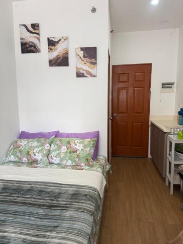 a bedroom with a bed and a wooden door at Bella's Flats in Bayanihan in Pajak