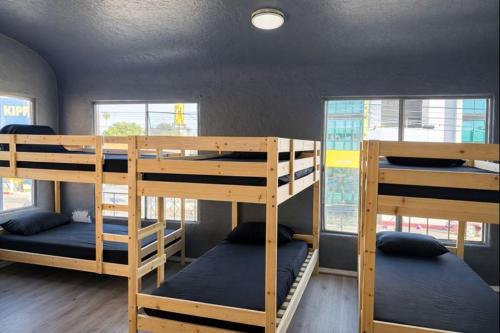 a dorm room with three bunk beds in it at Hoover Homes for the Soul in Los Angeles