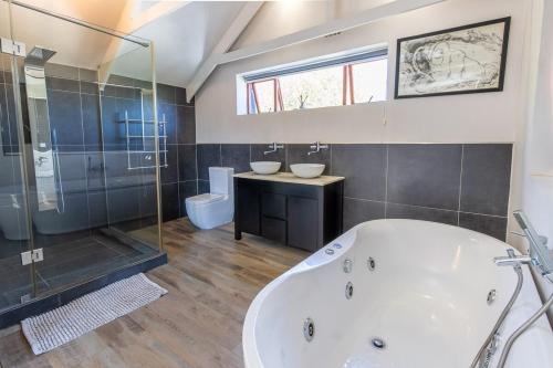 a bathroom with a tub and a shower and a sink at Barrydale Bliss in Barrydale