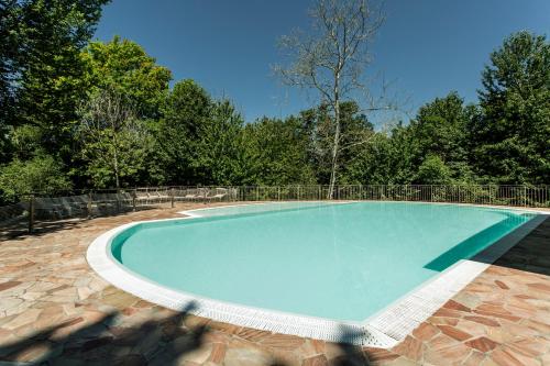 a large swimming pool in a yard with trees at Il Ruscello in Manerba del Garda