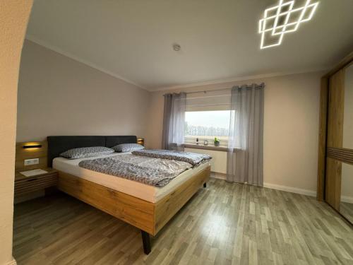 a bedroom with a large bed and a window at Ferienhaus in Glauchau, Garten, Grillmöglichkeit, Privatparkplatz, Kaffeevollautomat, Wlan, Netflix in Glauchau