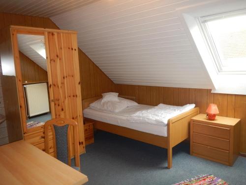 a bedroom with a bunk bed in a attic at Ferienwohnung Kornew in Dornum