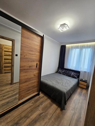 a bedroom with a bed and a large sliding door at Vistula Center in Płock