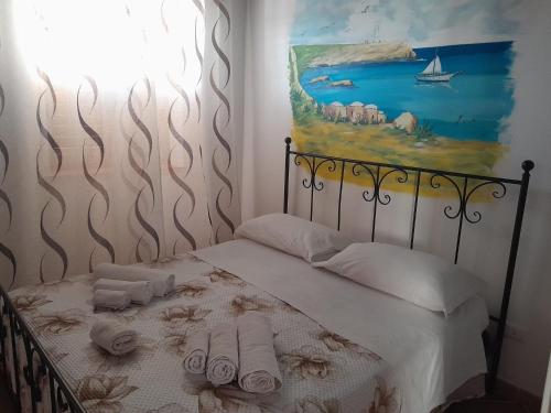 a bedroom with a bed with towels and a painting at Il Sole Di Lampedusa in Lampedusa