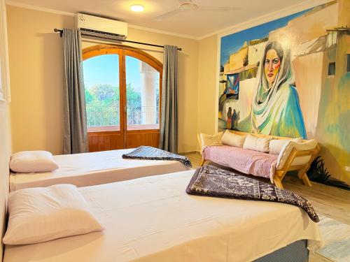 a room with three beds and a painting on the wall at Citadel Luxor in Luxor