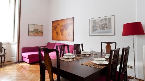 a dining room with a table and a pink couch at Italianway-Colonnetta in Milan