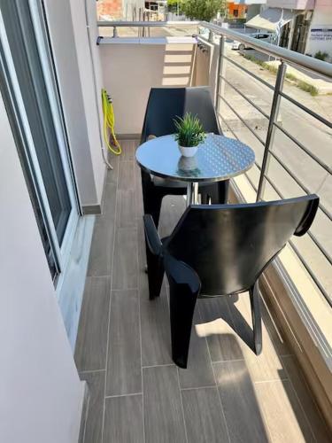 ein Tisch und ein Stuhl auf einem Balkon mit einem Tisch und einer Pflanze in der Unterkunft Marirena Seaside 1 in Kokkinos Pyrgos
