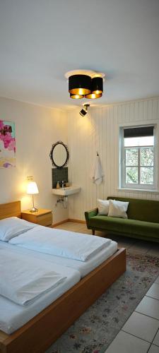 a bedroom with a large bed and a couch at Hostel am Burgenring - kostenloser Parkplatz, Zentrum, Self Check-In, Küche in Schlitz