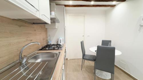 a kitchen with a sink and a stove and a table at Maison Studio in Chioggia