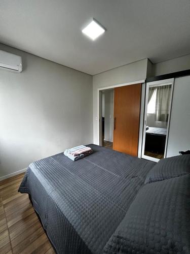 a bedroom with a bed with a blue comforter at Apartamento 1 quarto, sala e cozinha próximo ao Aeroporto in Vitória