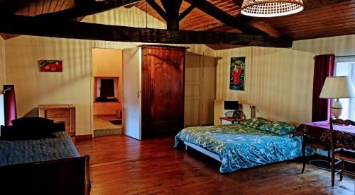a bedroom with a bed in a room with wooden floors at La Roche Cantin in Cherveux