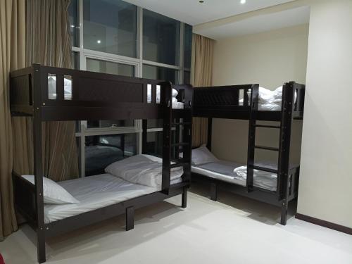 two black bunk beds in a room with a window at Universe Holiday Homes Burjuman in Sabkhah