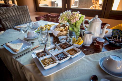 Resort Al Belvedere Salina في ليني: طاولة عليها أطباق من الطعام والزهور