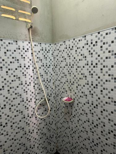 a shower in a bathroom with black and white tiles at Koh Jum Ozone Resort in Ko Jum