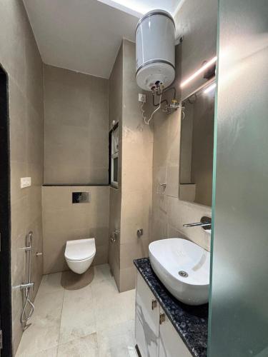 a bathroom with a sink and a toilet and a mirror at Hotel Ramya in Varanasi