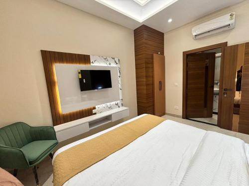 a bedroom with a bed and a tv on the wall at Hotel Ramya in Varanasi