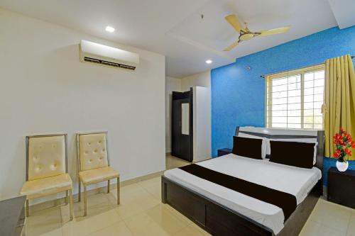 a bedroom with a bed and a blue wall at Hotel O Madhuram Lodge in Siddipet