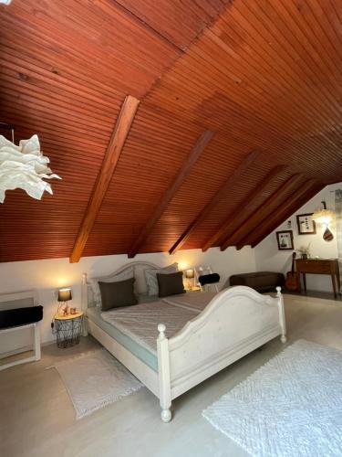 a bedroom with a large bed with a wooden ceiling at Holiday home Metulum in Oštarije