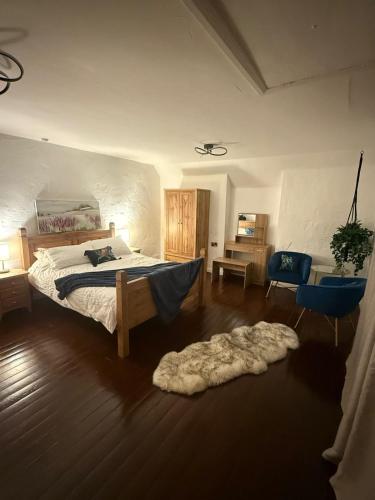 a bedroom with a bed and a chair and a rug at Lucy Cross Farm Cottage in Richmond