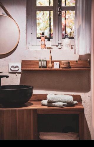 a bathroom with a counter with a sink and a window at MAISON ST LAURENT in Olargues