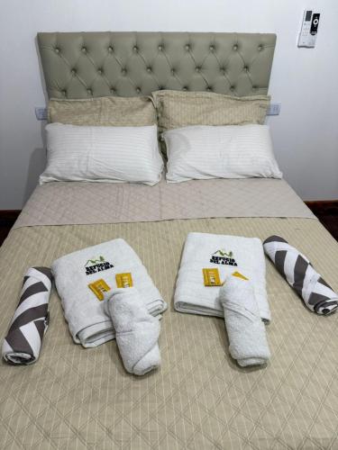 a bed with white towels and pillows on it at Refugio del Alma in Villa Anizacate