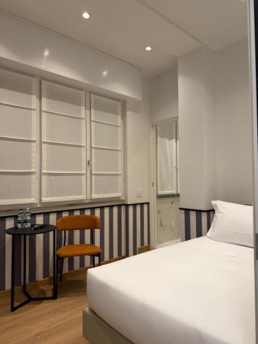 a bedroom with a bed and a table and a chair at HÕMA Certosa District in Milan