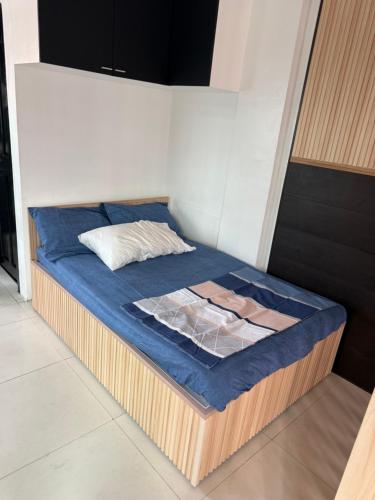 un letto in una stanza con un paravento blu di kap's che rental a Manila