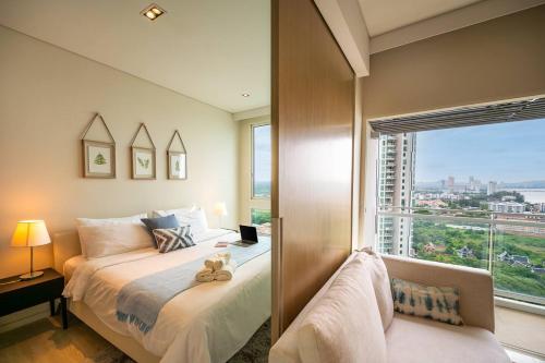 a bedroom with a bed and a large window at HighFloor Seaview Condo,Pool by the beach,Kitchen,Gym,WIFI in Jomtien Beach