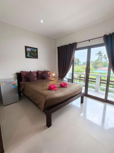 a bedroom with a bed with two red pillows on it at Jigsaw Cafe & Resort in Ban Na We