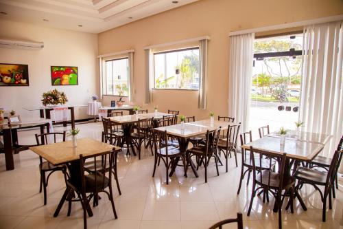 a room with tables and chairs in a restaurant at Hotel Oceania in Eunápolis