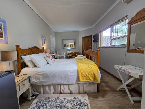 a bedroom with a bed and a desk and a window at Modern rustic private flat in Bloemfontein