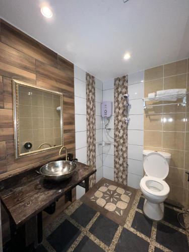 a bathroom with a toilet and a sink at Papalu Villa in Kuala Penyu