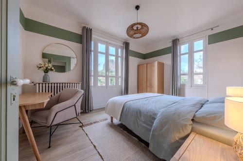 a bedroom with a bed and a desk and a table at La Villa des Coccinelles in Olivet