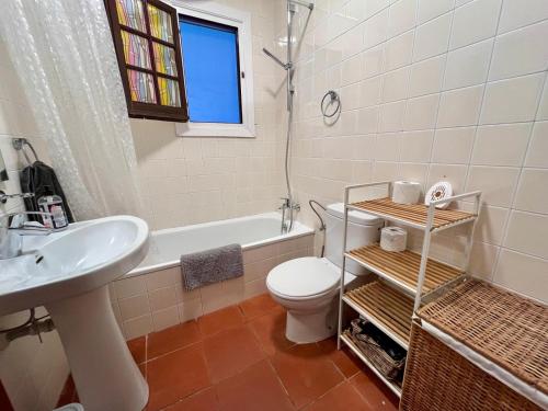 a bathroom with a toilet and a sink and a tub at Casa Cristalina Menorca in Fornells