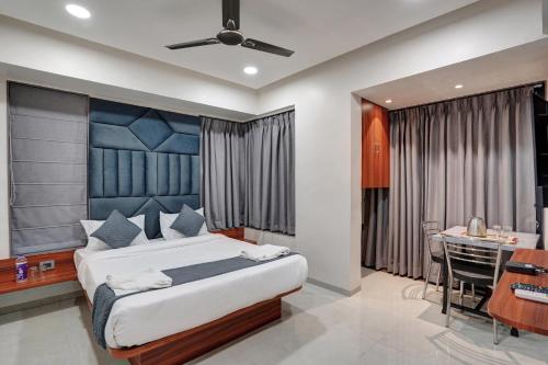 a bedroom with a bed and a desk and a table at Hotel Samarth Elite Baner - Indian Guests Only in Pune