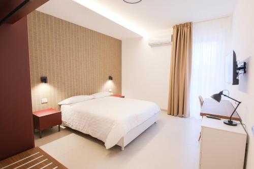 a bedroom with a white bed and a window at ARQO Apartments in Marcianise
