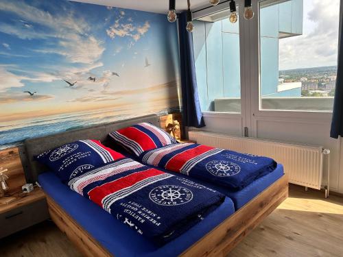 a bed with pillows on it in a room with a window at Ebbe u Flut Bremerhaven in Bremerhaven