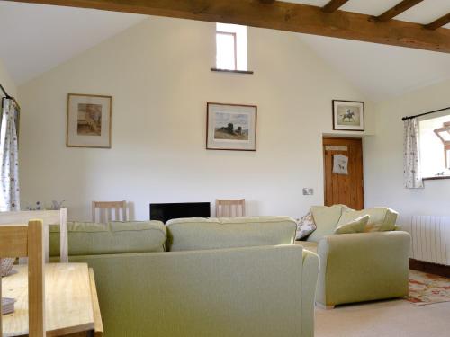 a living room with a couch and chairs and a table at Brandy's Barn in Middleham