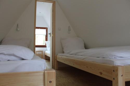 a bedroom with two twin beds and a mirror at Glücklich am Strand - Ruhe im Kiefernwald mit Terrasse & Hund willkommen - Heinrich in Trassenheide