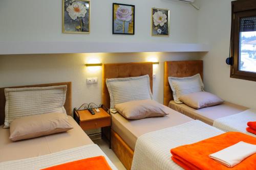 a room with two beds and a nightstand between them at Hotel Makedonia in Évzonoi