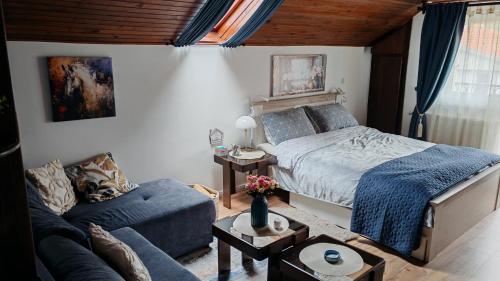 a bedroom with a bed and a couch at Apartman Pavle Mladenovac in Mladenovac